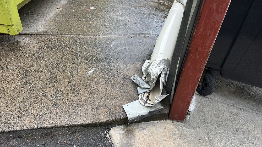 Downpipe discharging right beside the footings, wetting the soil, found during a defect investigation inspection in Richmond
